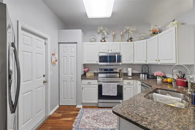 a kitchen with stainless steel appliances granite countertop a refrigerator sink and stove