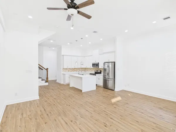a kitchen with a refrigerator and white cabinets