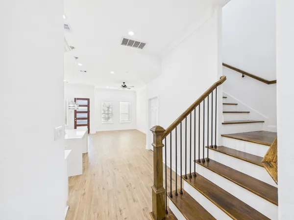 a view of a hallway with wooden floor and entryway