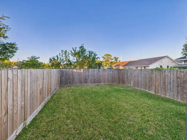 a view of a backyard with wooden fence