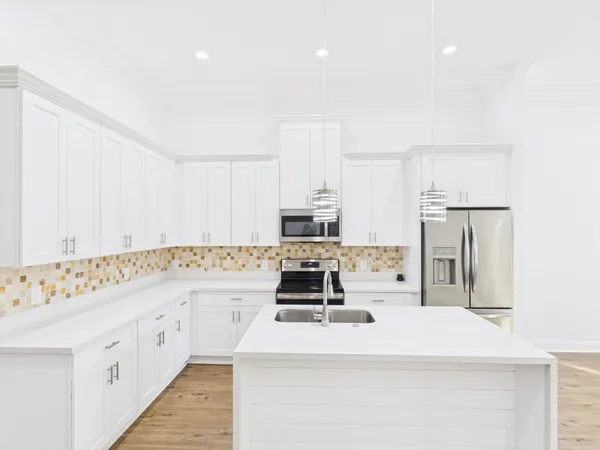 a kitchen with granite countertop a sink stove and refrigerator