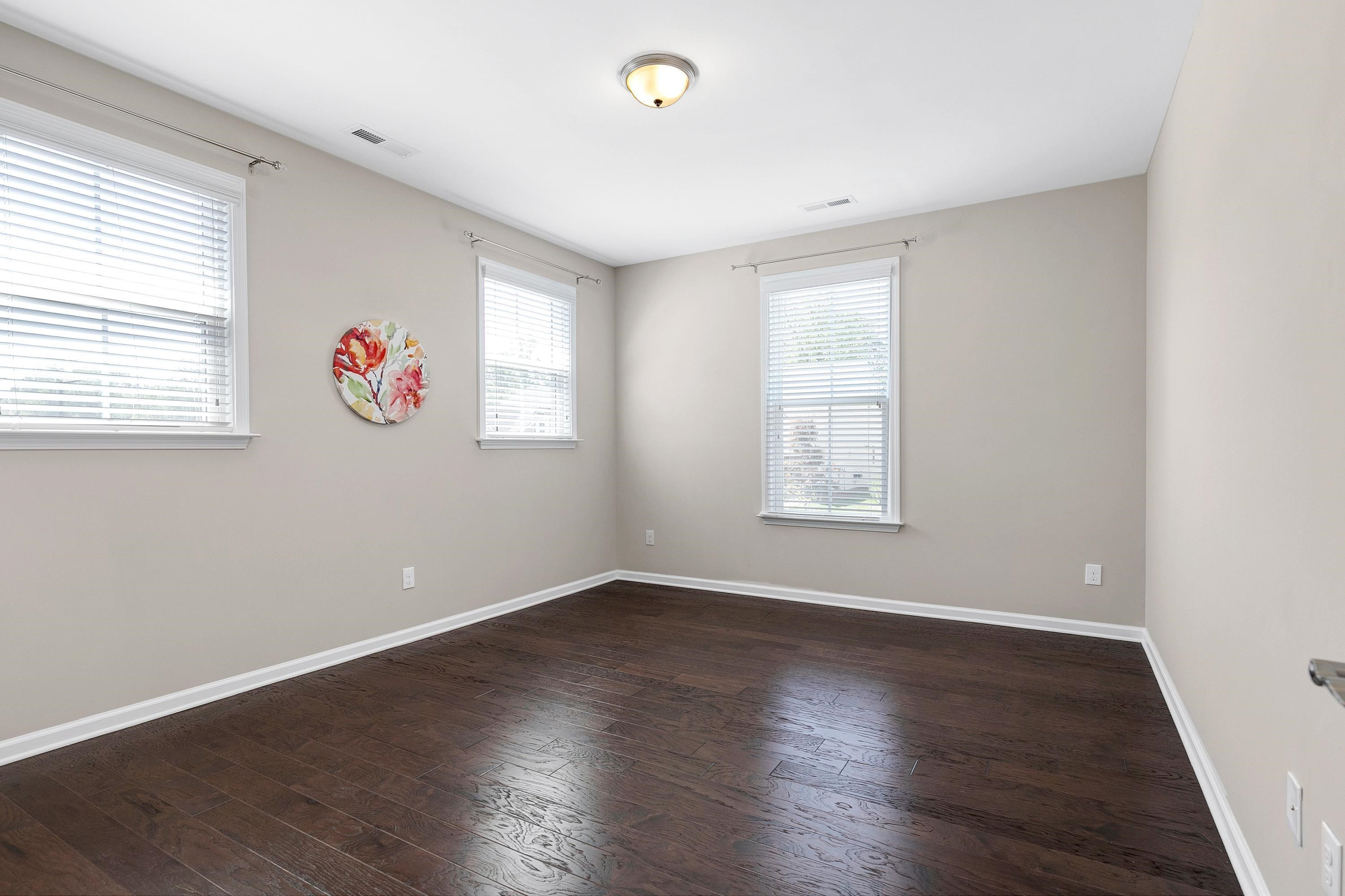 811 Atticus Way Durham, NC 27703 - Photo 17 of 33 an empty room with wooden floor and windows