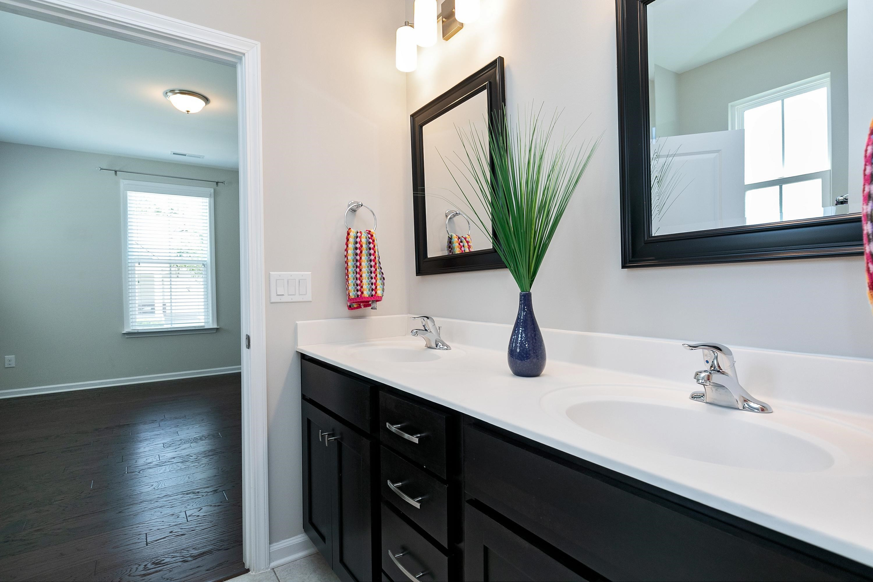 811 Atticus Way Durham, NC 27703 - Photo 20 of 33 a bathroom with a double vanity sink and a mirror