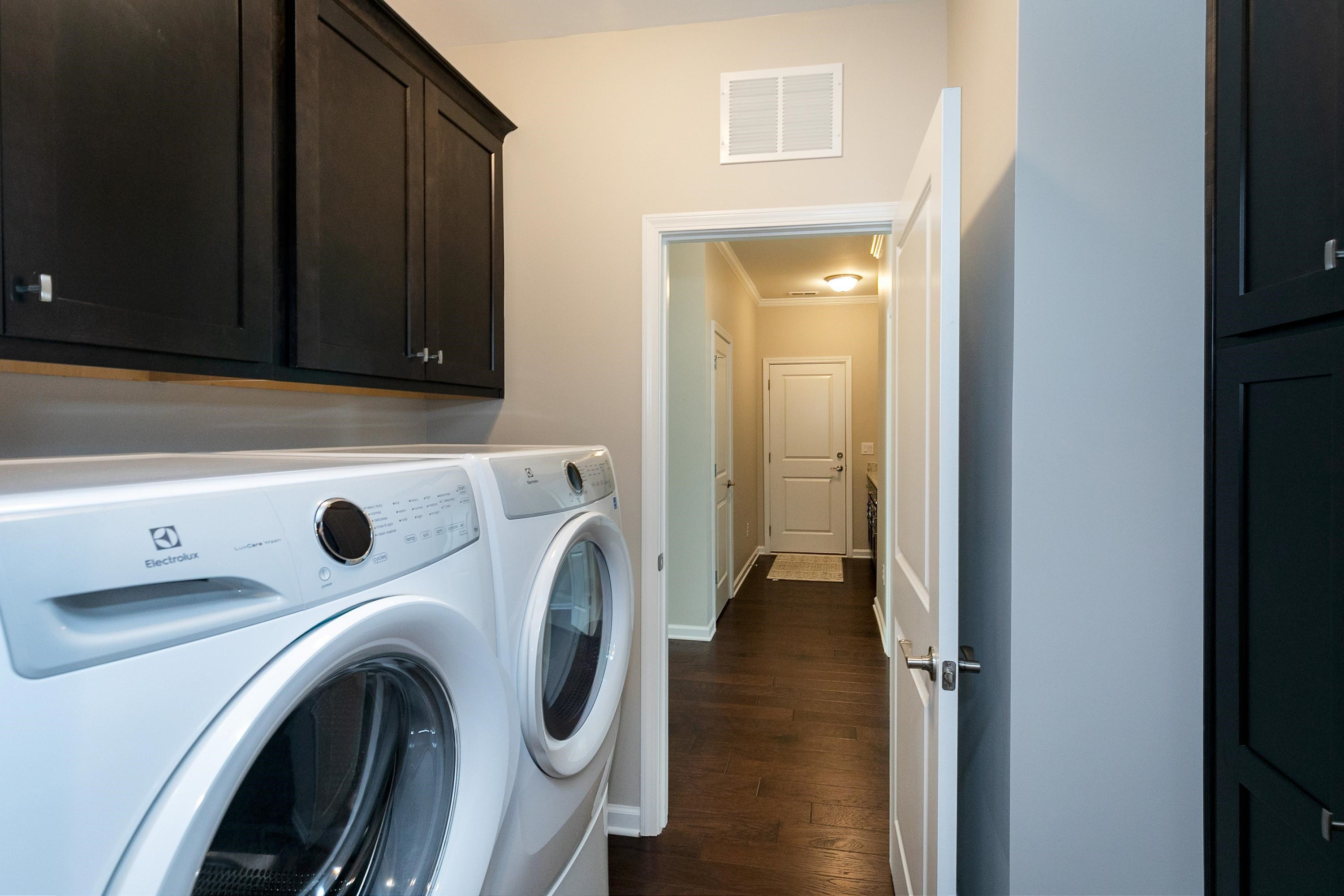 811 Atticus Way Durham, NC 27703 - Photo 25 of 33 a view of washer and dryer with kitchen in the background