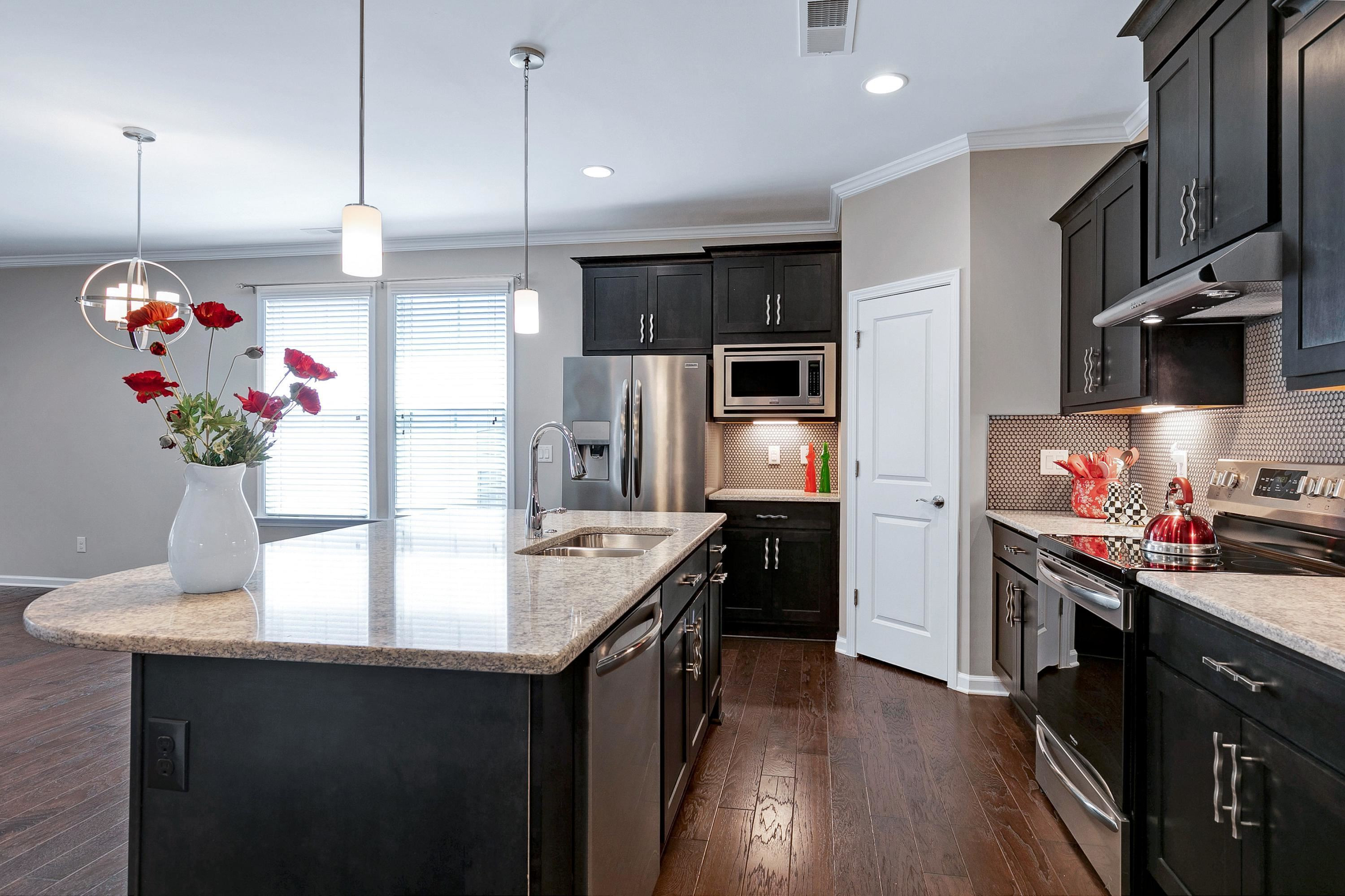 811 Atticus Way Durham, NC 27703 - Photo 3 of 33 a kitchen with kitchen island granite countertop a sink stove and refrigerator