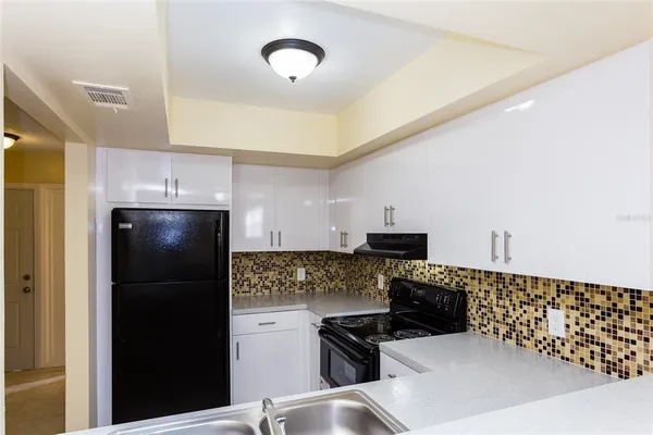 a kitchen with a refrigerator and a stove top oven