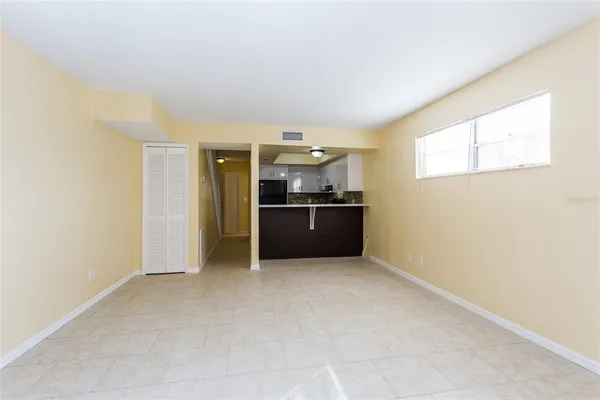 an empty room with kitchen and windows