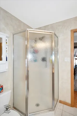 a bathroom with a glass shower door and a mirror