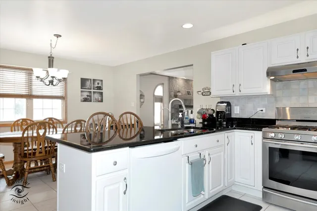 a kitchen with white cabinets and appliances