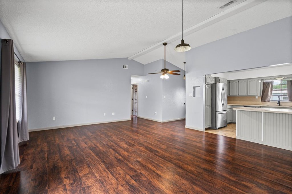 650 West Austin Street Luling, TX 78648 - Photo 5 of 18 Rich hardwood-style flooring flows through this open concept living area and kitchen, featuring vaulted ceilings.