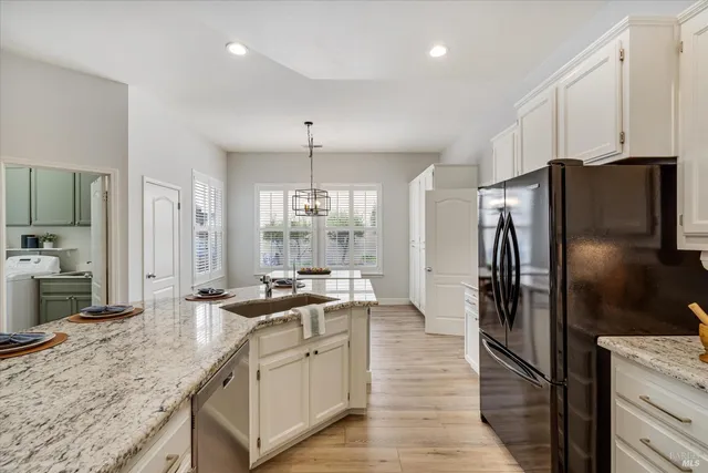 a kitchen with stainless steel appliances granite countertop a refrigerator a stove and a sink