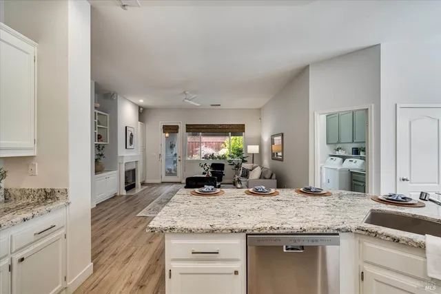 a kitchen with granite countertop a sink stove and cabinets