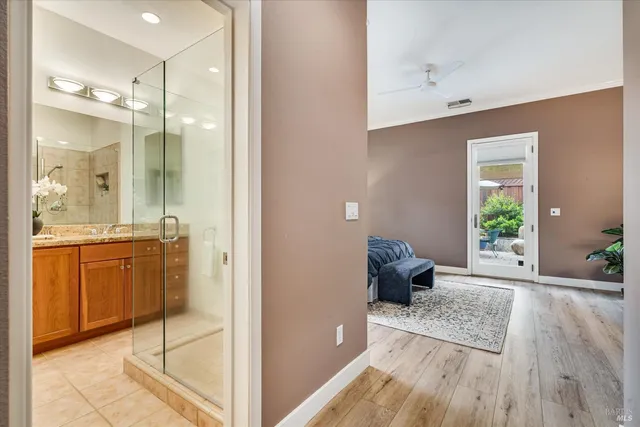 a view of a hallway with wooden floor and furniture