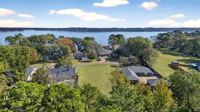 an aerial view of a house with a garden and lake view