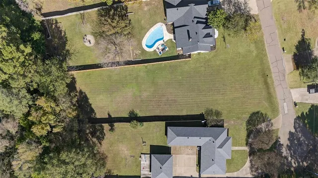 an aerial view of a house with a yard and large trees