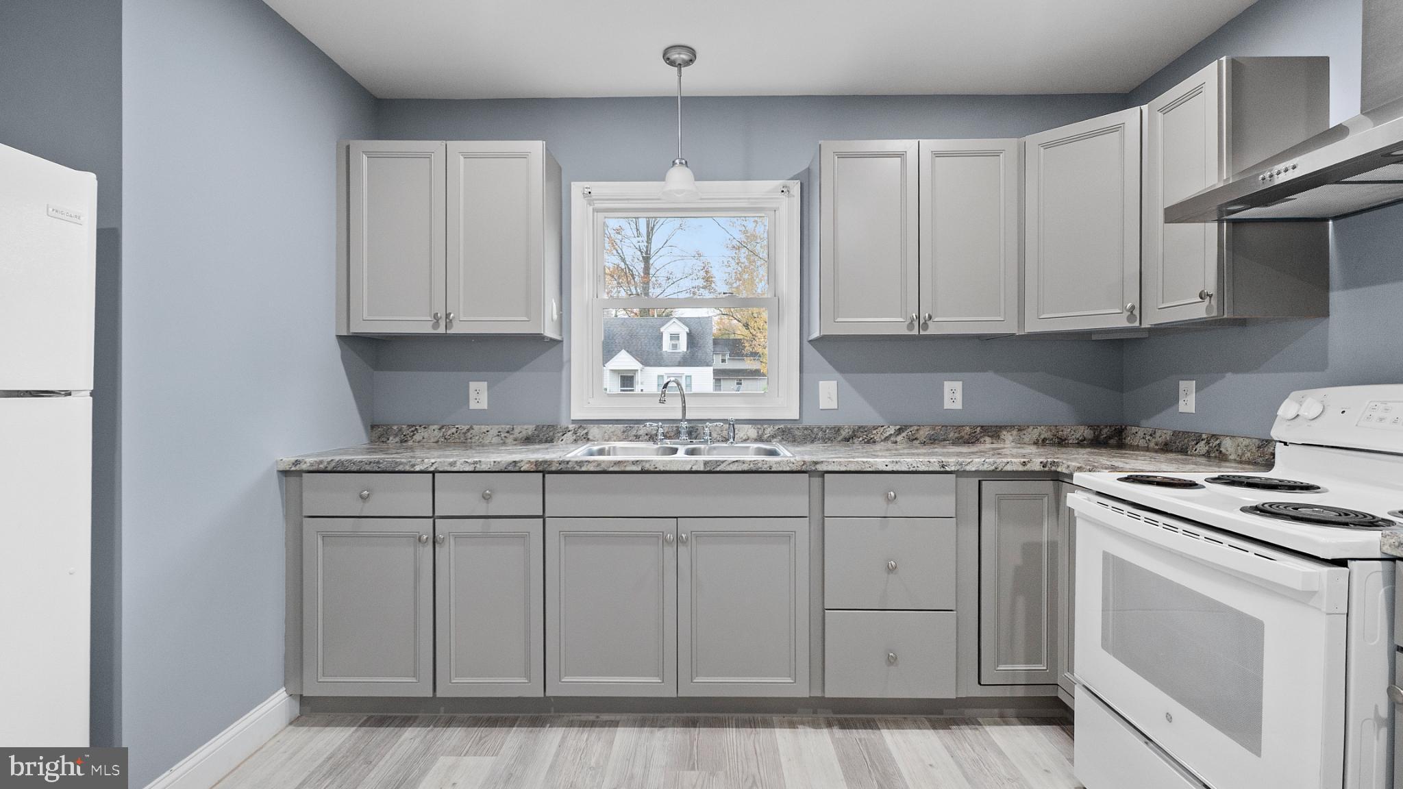 1007 Spring Avenue Salisbury, MD 21804 - Photo 1 of 13 a kitchen with granite countertop white cabinets and white appliances