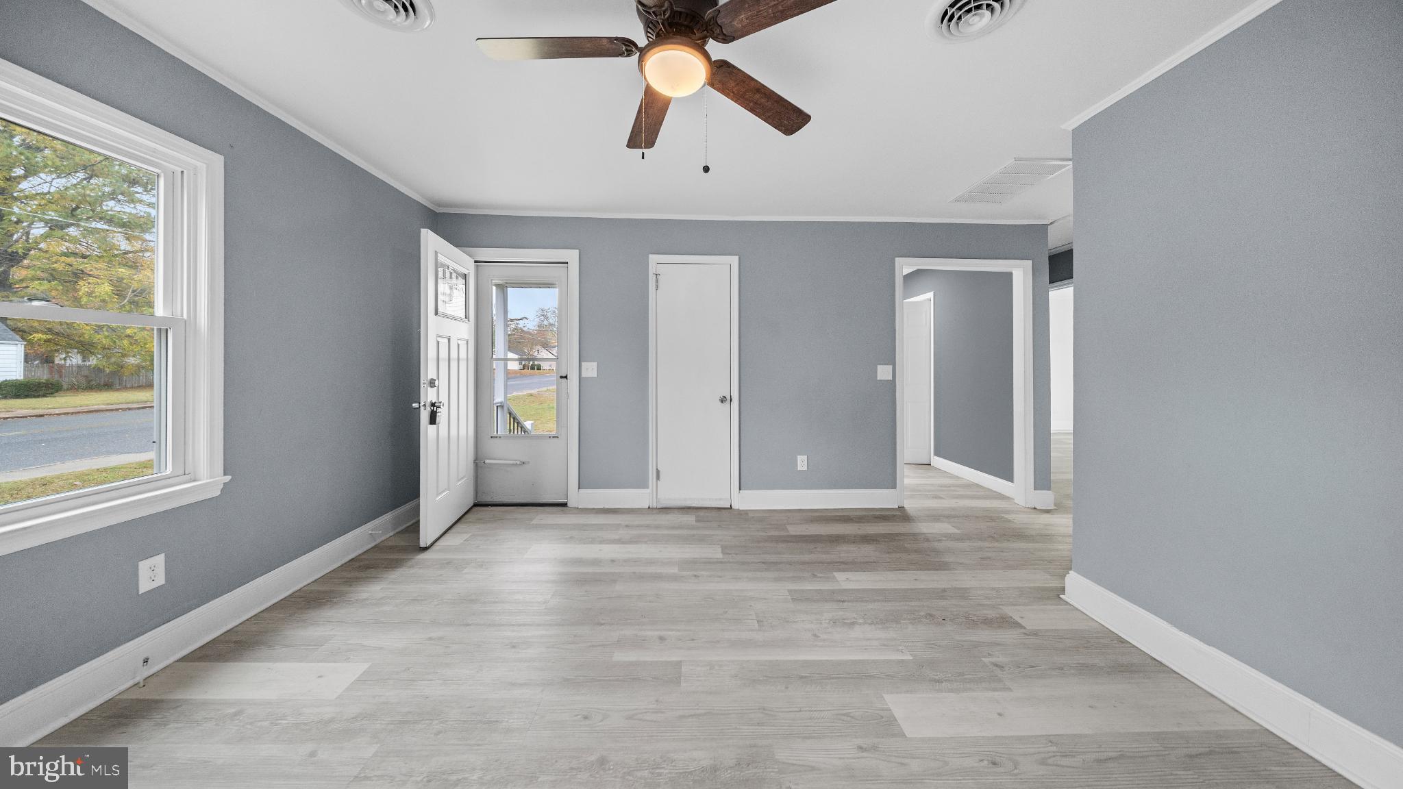 1007 Spring Avenue Salisbury, MD 21804 - Photo 4 of 13 an empty room with chandelier fan and windows