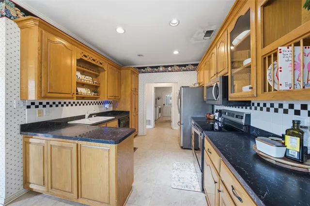 a kitchen with stainless steel appliances granite countertop a sink and cabinets