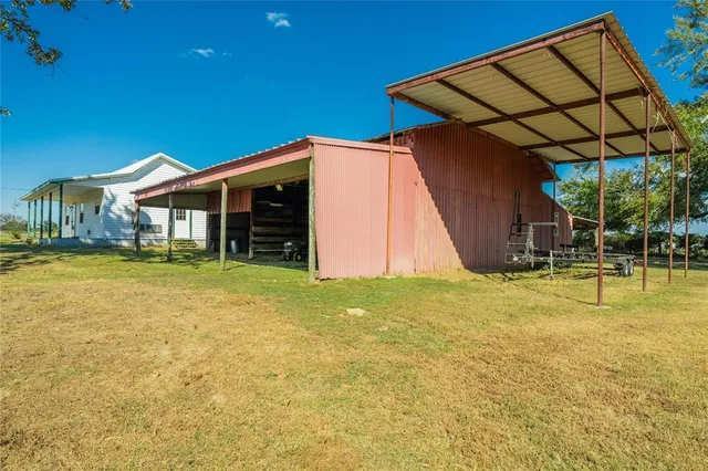 a backyard of a house with barbeque oven table and chairs
