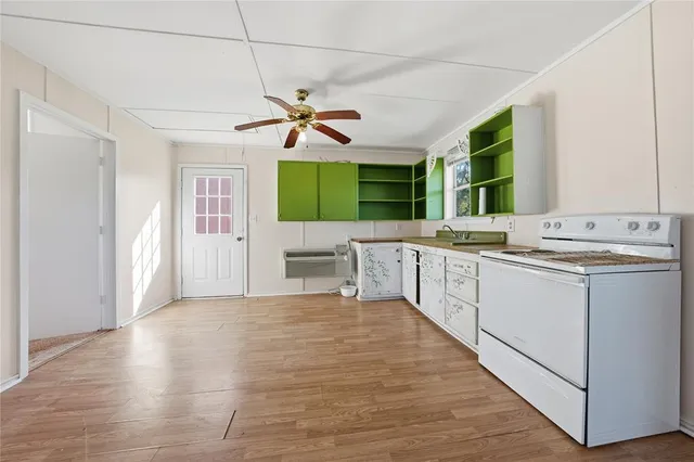 a white kitchen with a sink and a stove top oven
