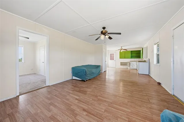 a view of an empty room with window and wooden floor