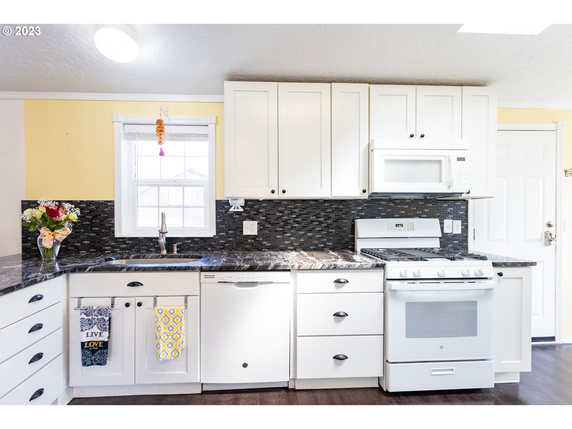 1045 Chenoweth Road The Dalles, OR 97058 - Photo 13 of 35 a kitchen with granite countertop a stove a sink and white cabinets