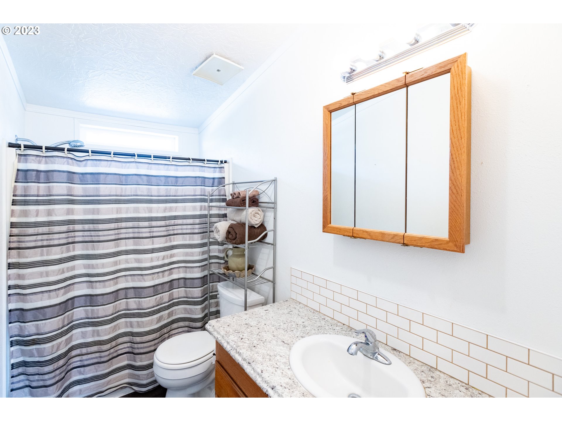 1045 Chenoweth Road The Dalles, OR 97058 - Photo 24 of 35 a bathroom with a sink a toilet and shower curtain