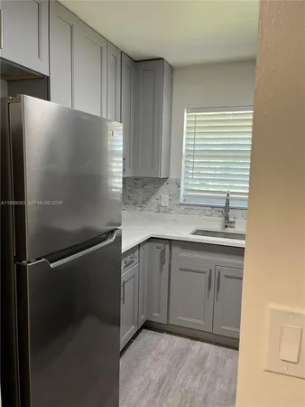 a kitchen with granite countertop a refrigerator and a sink