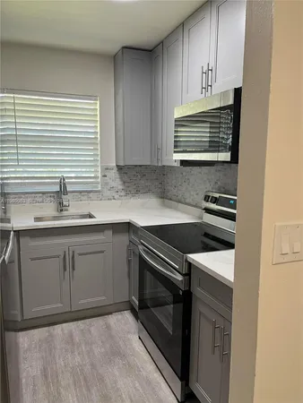 a kitchen with a sink stove and cabinets