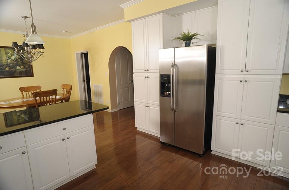 490 Cress Road Mount Ulla, NC 28125 - Photo 13 of 23 a kitchen with stainless steel appliances granite countertop a refrigerator a sink and white cabinets with wooden floor