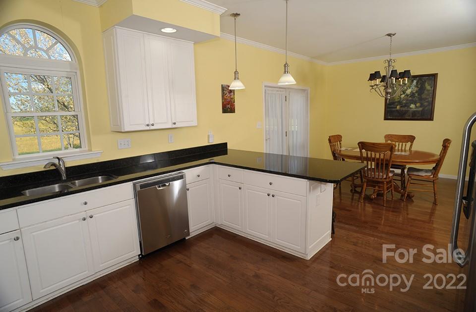 490 Cress Road Mount Ulla, NC 28125 - Photo 10 of 23 a kitchen with granite countertop a stove a sink a dining table and chairs