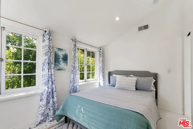 a bedroom with a large window and a bed