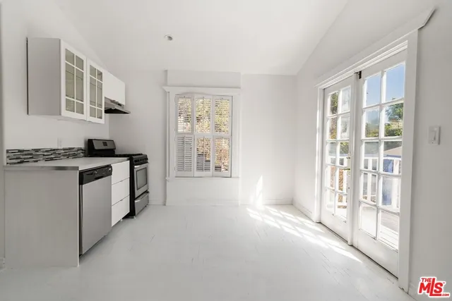 a kitchen with granite countertop a stove a sink and a refrigerator