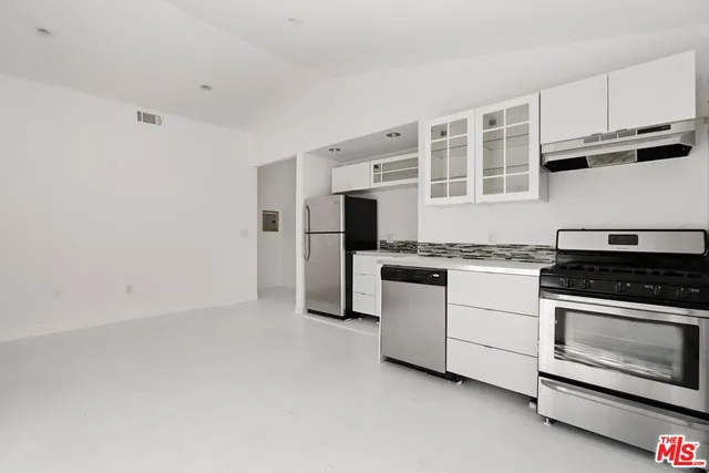 a kitchen with granite countertop white cabinets and stainless steel appliances