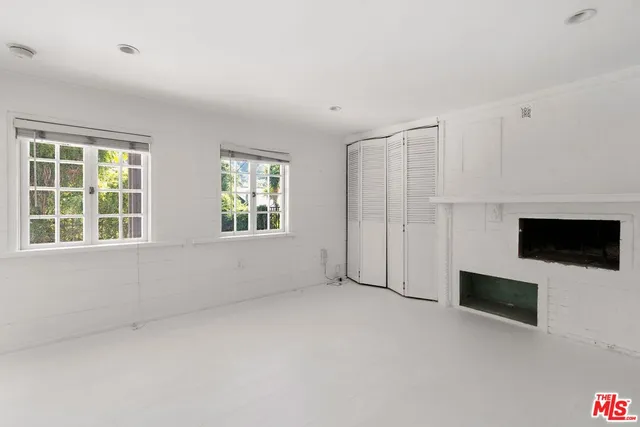 a view of empty room with a fireplace and window