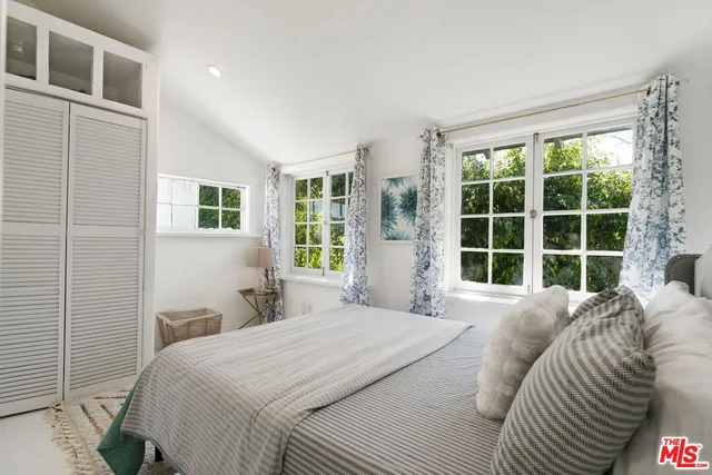 a bedroom with a bed and glass window
