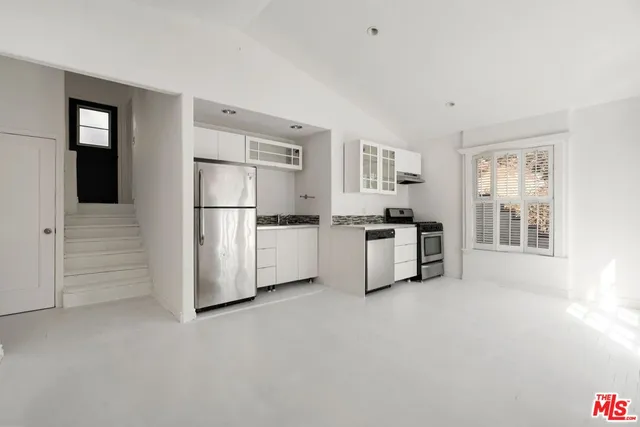 a kitchen with stainless steel appliances a refrigerator and a stove top oven