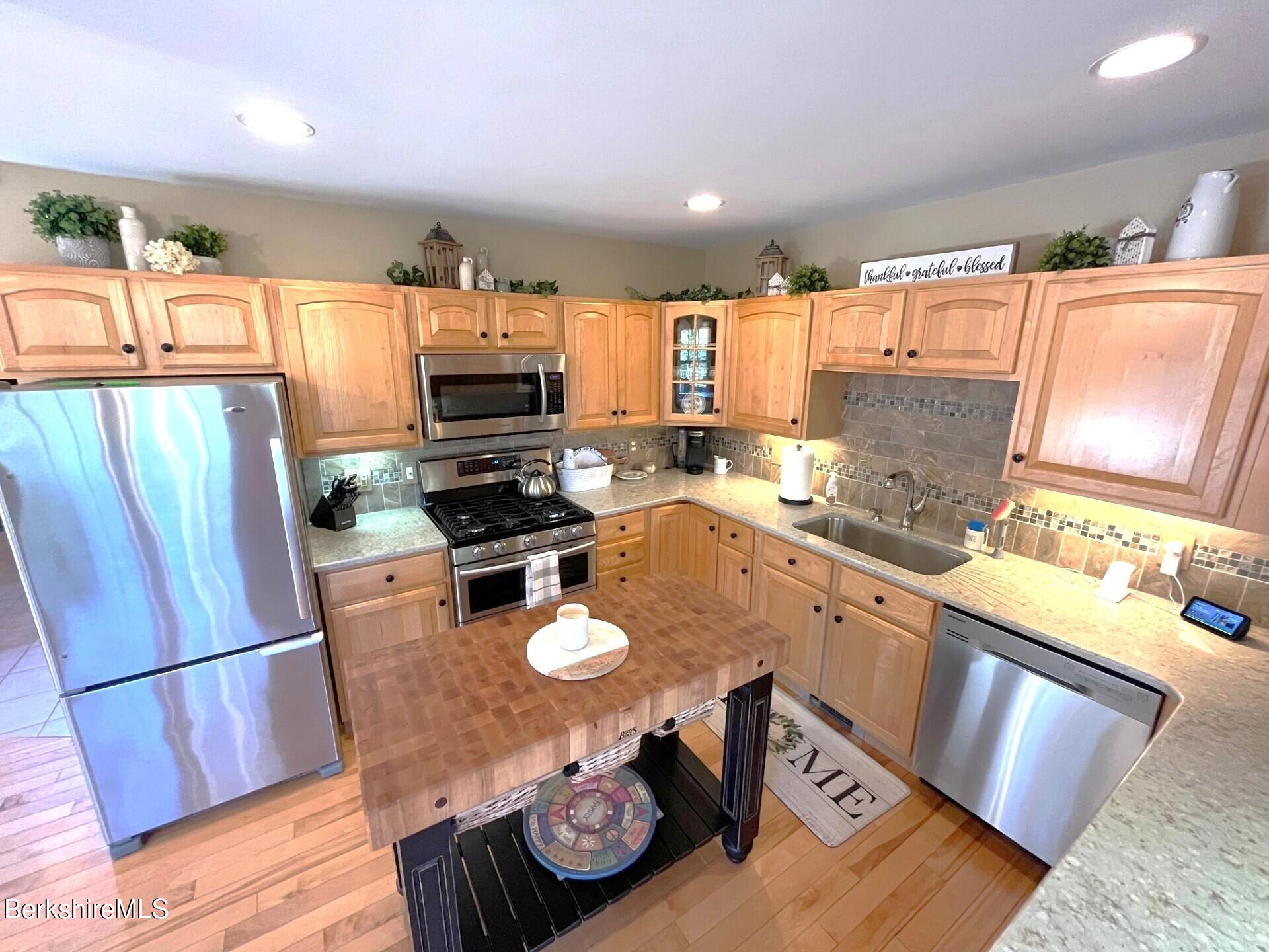 1020 Cascade Street Pittsfield, MA 01201 - Photo 16 of 75 a kitchen with stainless steel appliances granite countertop a refrigerator a stove a sink a microwave oven with a dining table and chairs