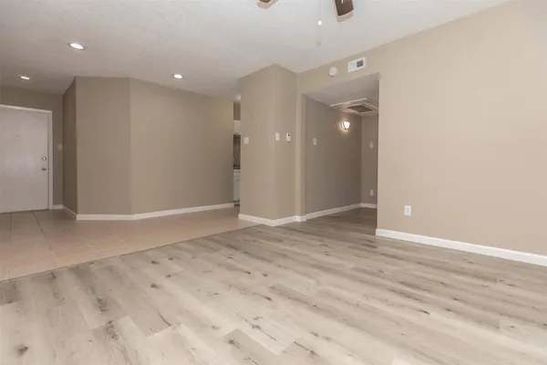 an empty room with wooden floor and mirror