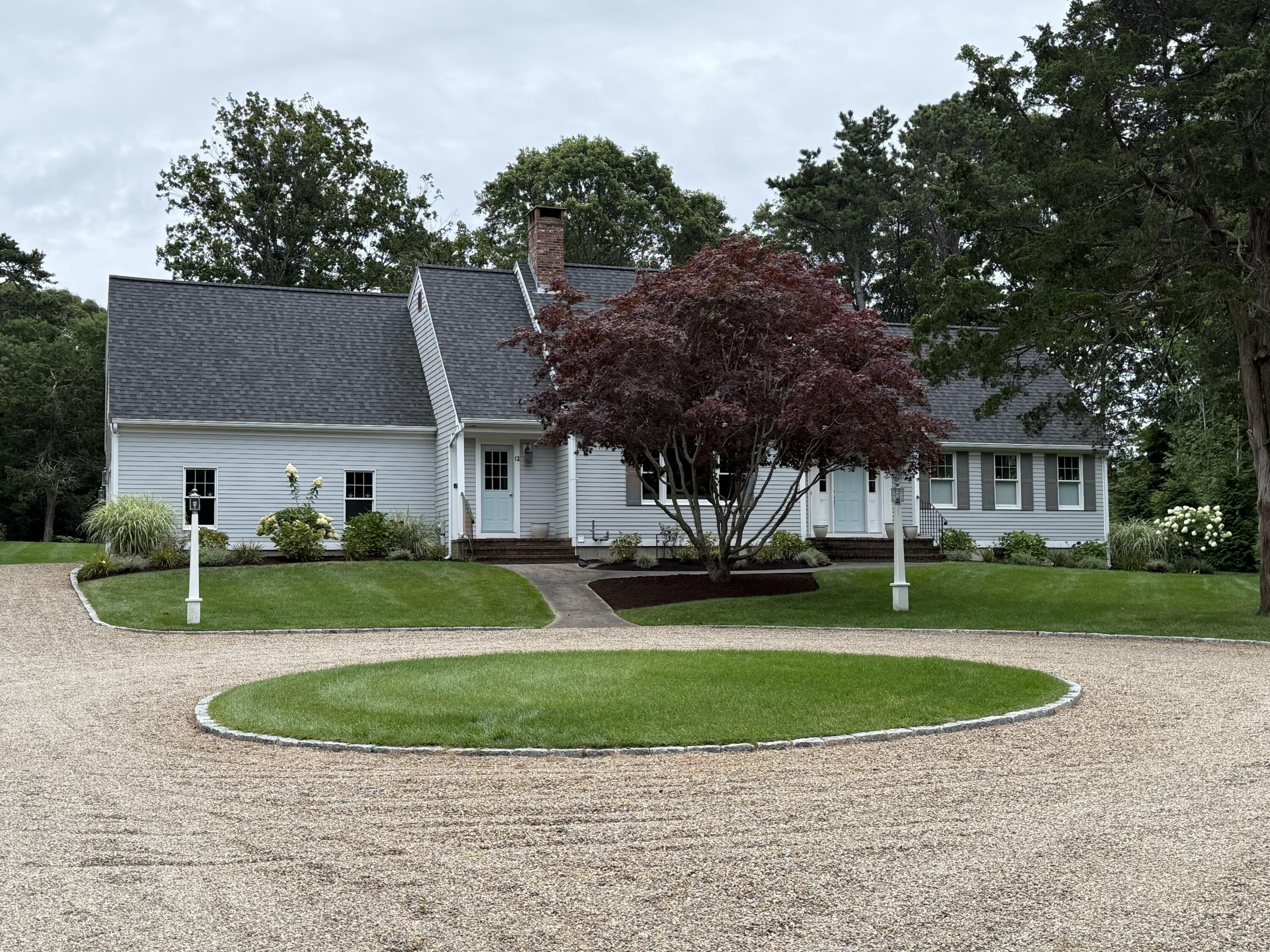 12 Paddocks Path East Dennis, MA 02638 - Photo 10 of 64 a front view of a house with a yard and garage