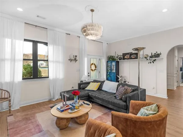 a living room with furniture and a chandelier