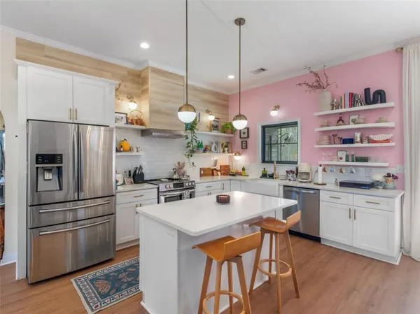 a kitchen with stainless steel appliances a stove a sink a refrigerator a center island and appliances