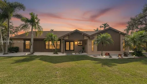 a front view of a house with swimming pool and porch with furniture
