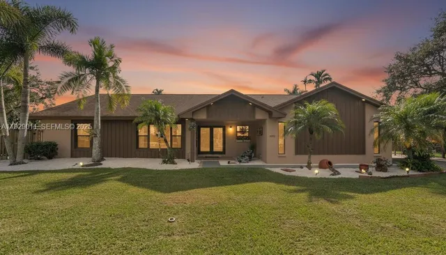 a front view of a house with swimming pool and porch with furniture