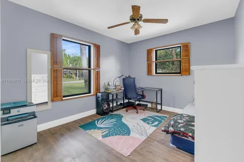 a living room with furniture dining table a chandelier and a potted plant
