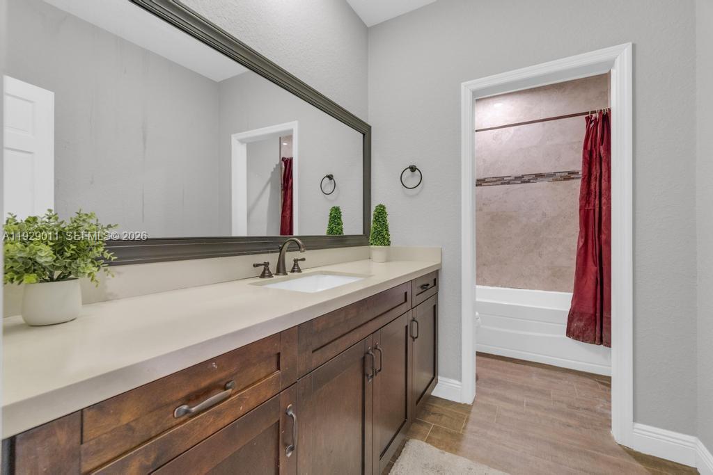 16900 Southwest 276th Street Homestead, FL 33031 - Photo 16 of 22 a bathroom with a granite countertop sink a mirror and shower