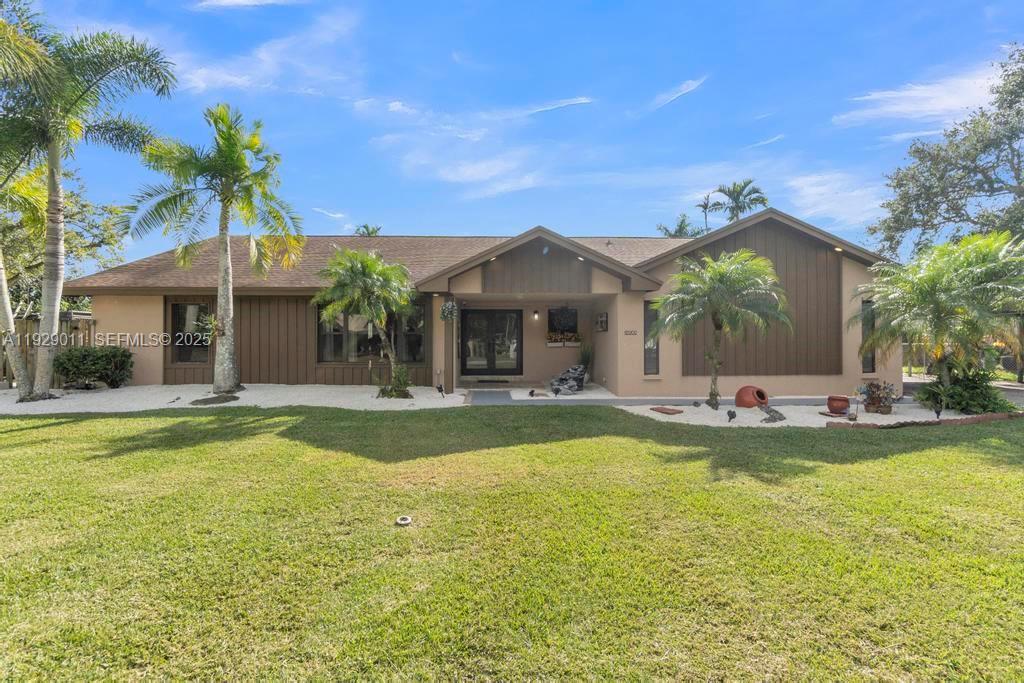 16900 Southwest 276th Street Homestead, FL 33031 - Photo 22 of 22 a view of a house with swimming pool and a yard with palm trees