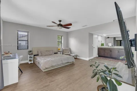 a spacious bedroom with a bed chandelier and a window