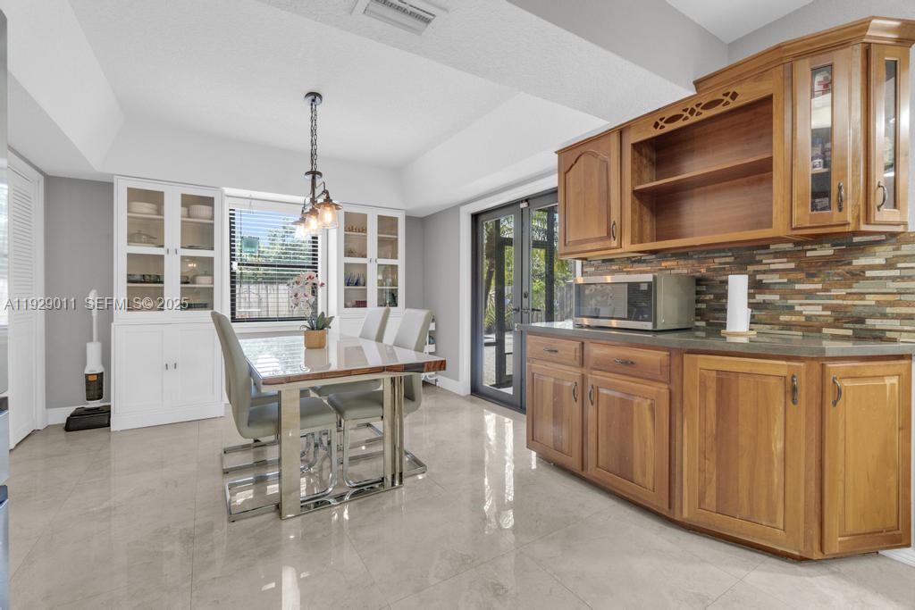 16900 Southwest 276th Street Homestead, FL 33031 - Photo 8 of 22 a workspace with kitchen island granite countertop furniture and a flat screen tv