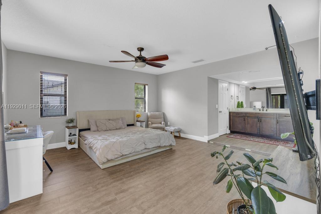 16900 Southwest 276th Street Homestead, FL 33031 - Photo 9 of 22 a spacious bedroom with a bed chandelier and a window